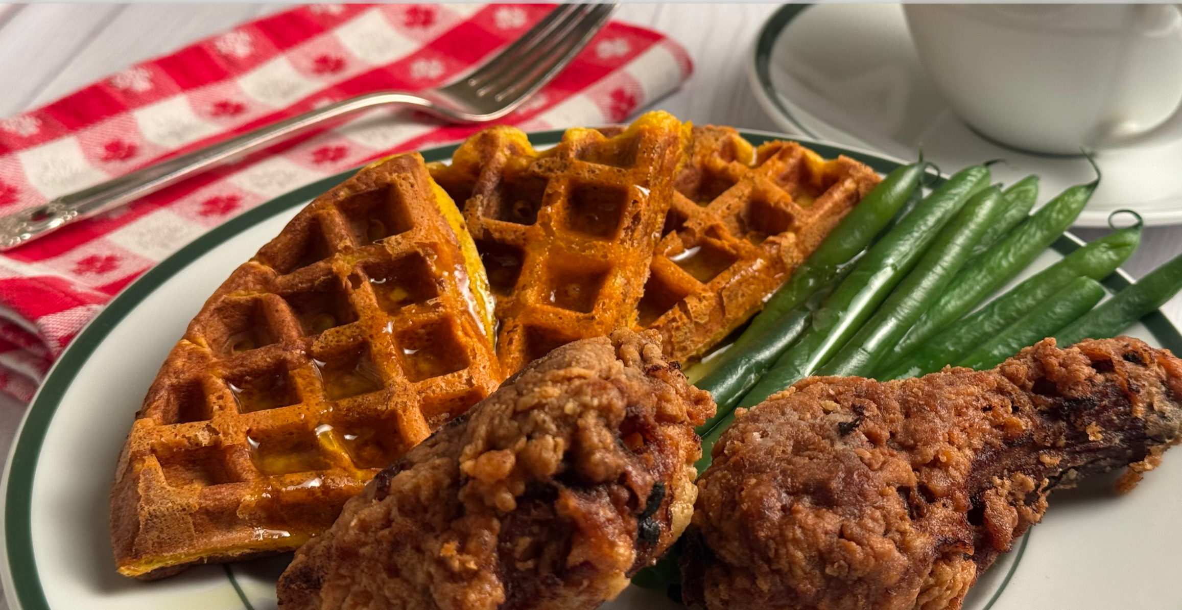 Chicken and Waffles shown on a breakfast table with cup of coffee