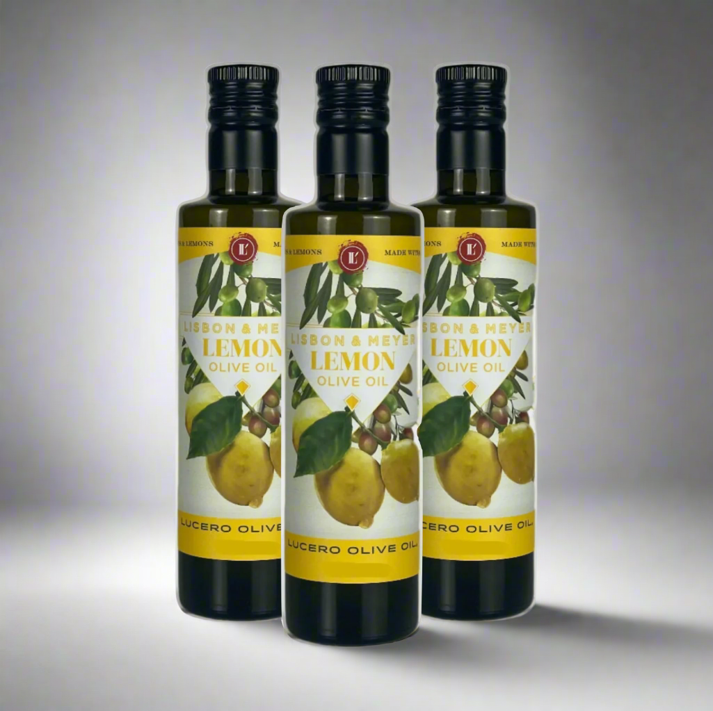 Three bottles of Lucero Lemon Olive Oil (Agrumato Style) are shown on a kitchen counter.