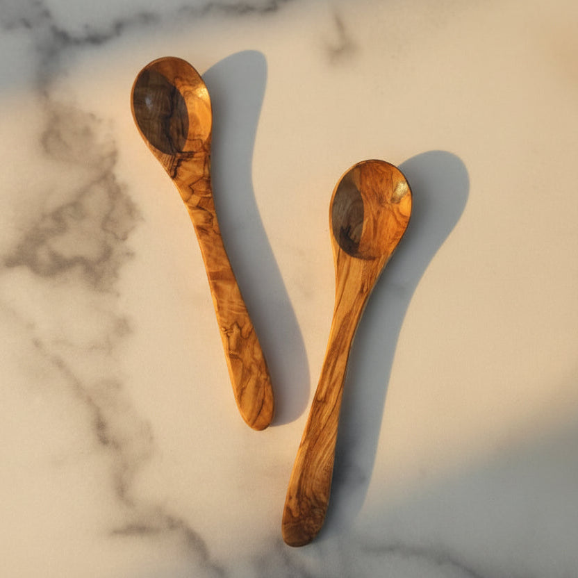 Two wooden spoons on a marble surface