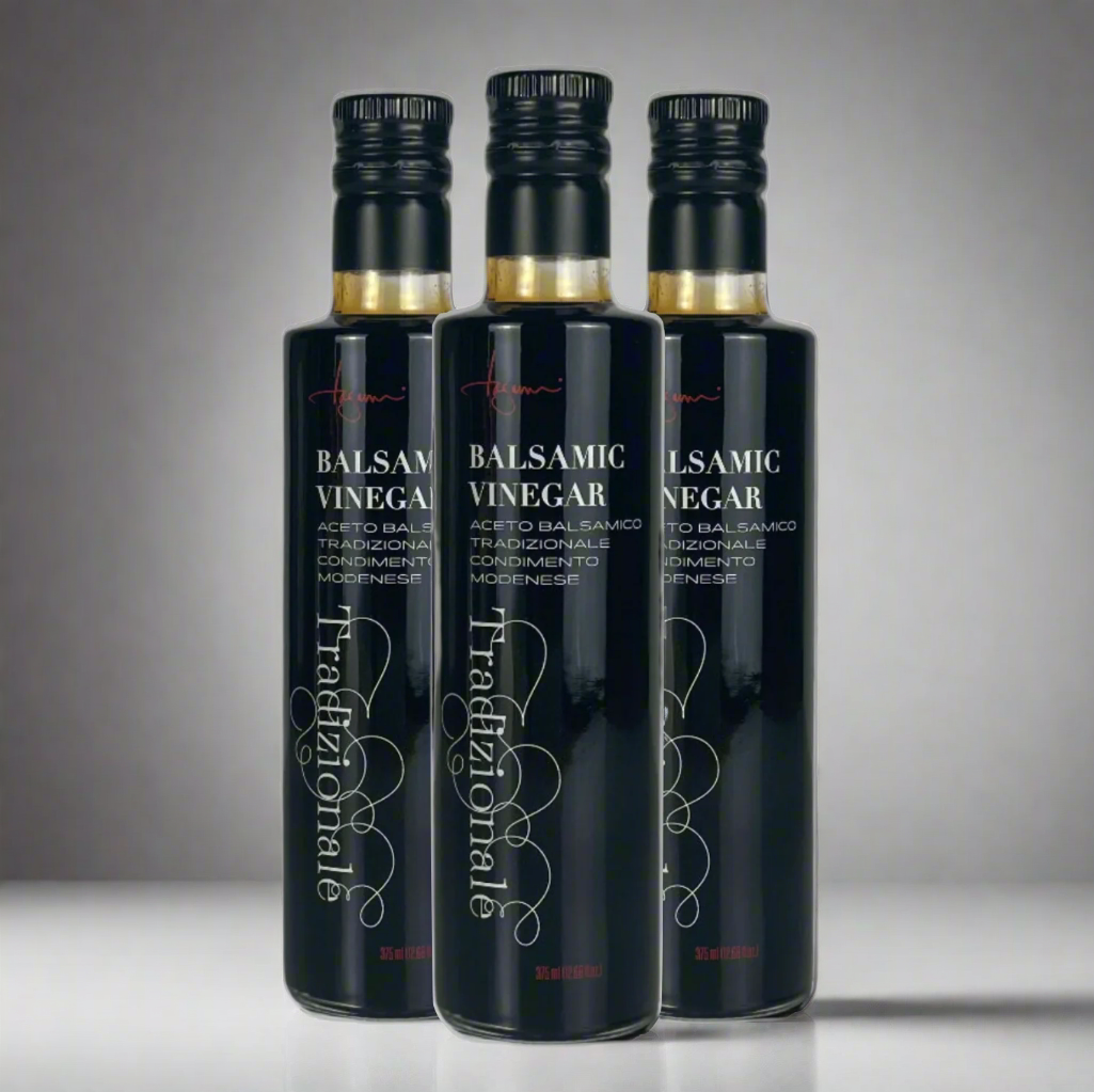Three bottles of Traditional Balsamic Vinegar on a plain background