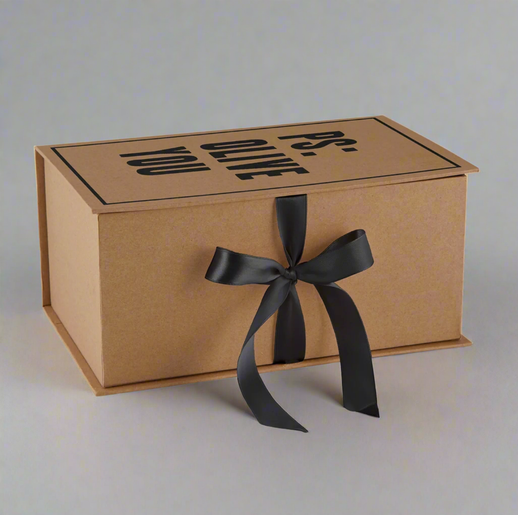 This is a side shot showing what the Olive and Pits Bowls gift box looks like when closed. It is a "book style" box with a hinge on the left and tied with a satin bow on the side.