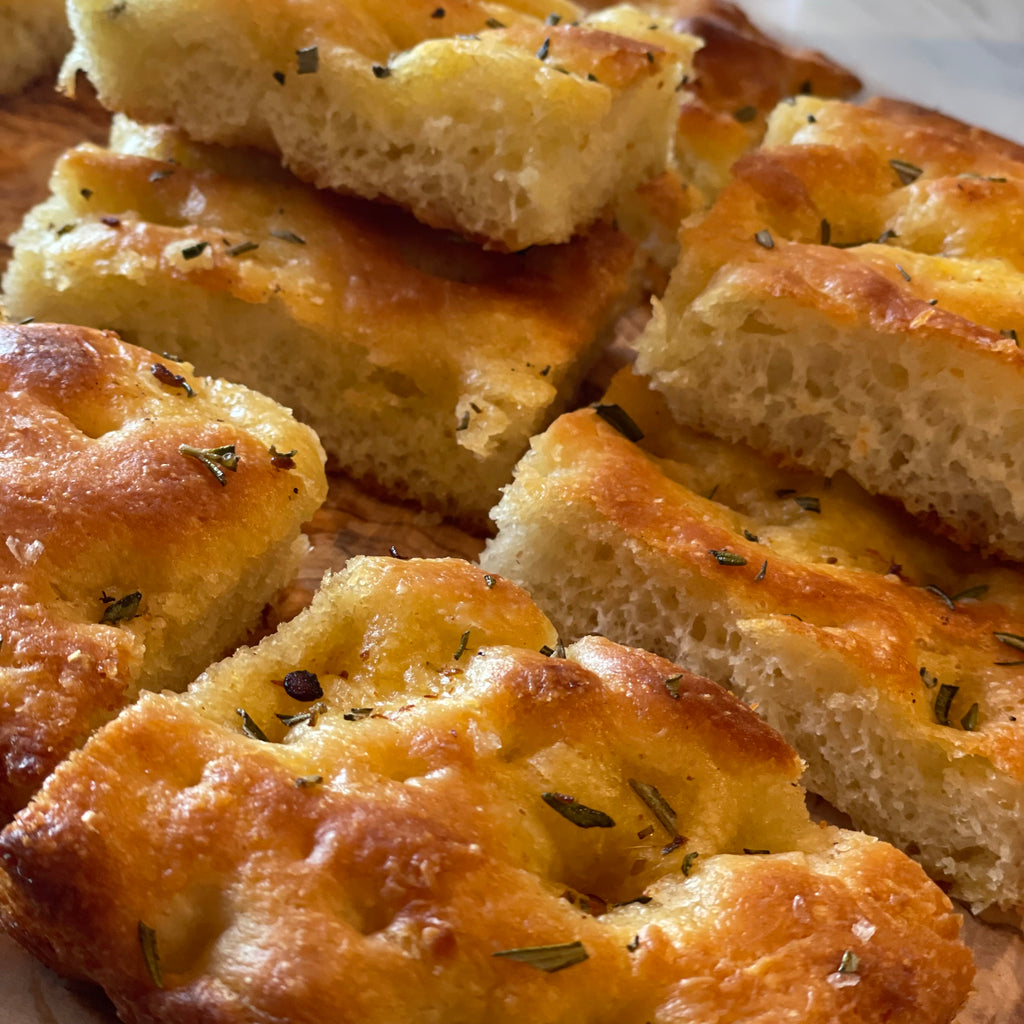 Close up images of sliced focaccia barese showing specks of rosemary and salt