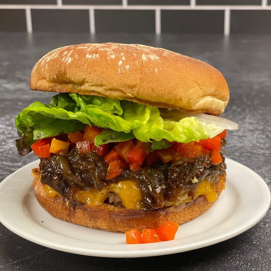 A classic cheeseburger shown with lettuce, avocado, balsamic caramelized onions and smoky red pepper relish.