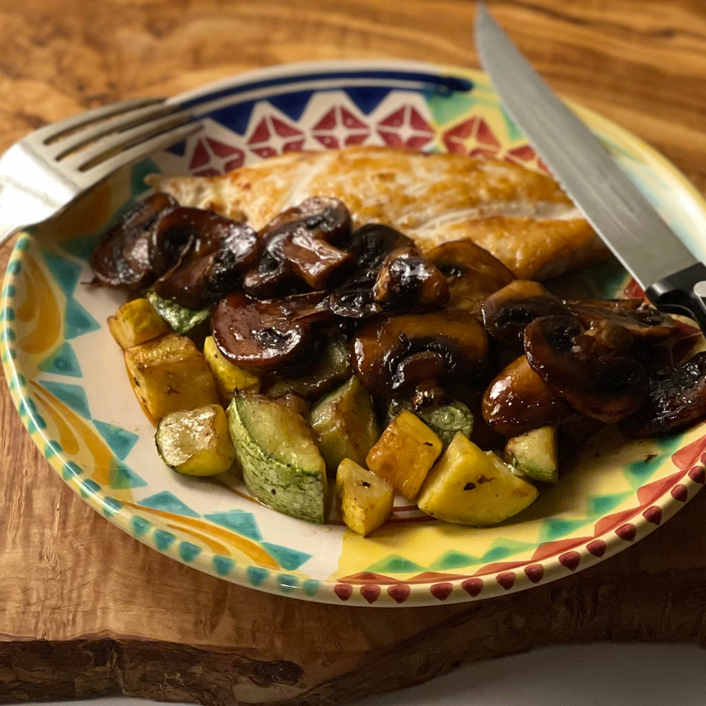 Caramelized balsamic mushrooms cascade off a sautéed chicken breast, and a bit of summer squash fills the rest of the plate.