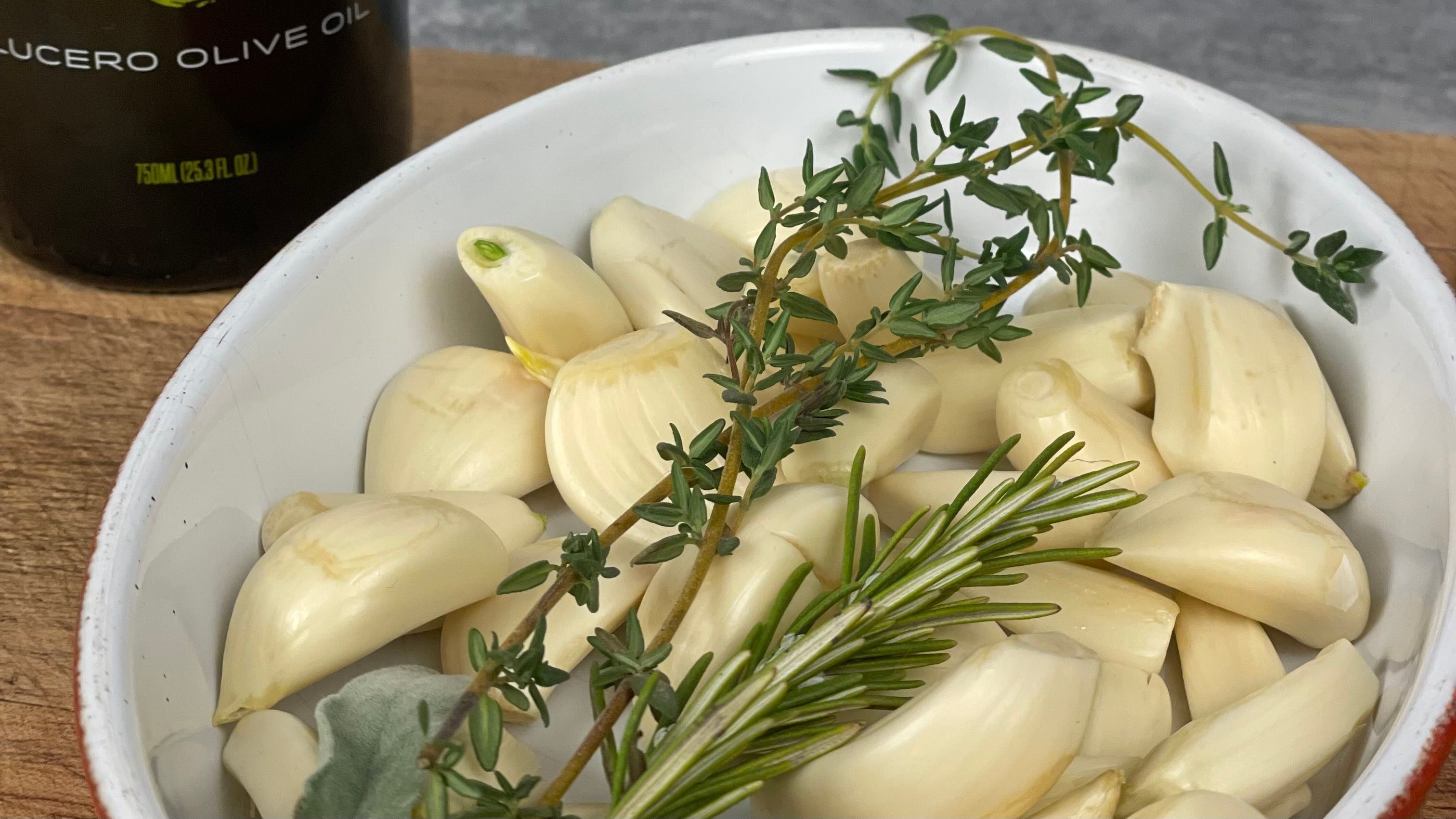 Clean raw garlic cloves, fresh rosemary, and fresh thyme.