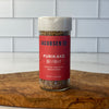Close up image of a jar of Jacobsen's Furikake on an olivewood board in a tile kitchen.