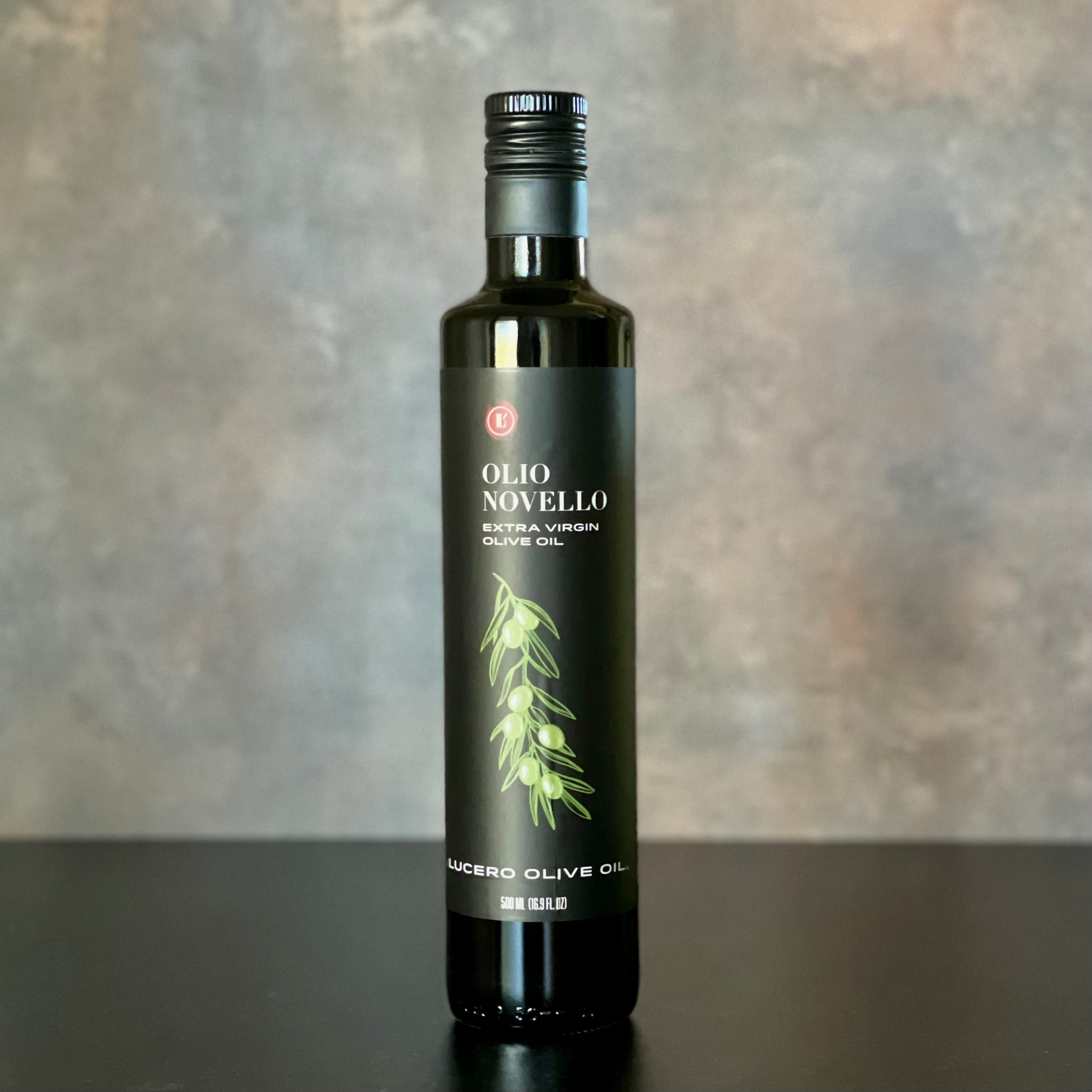  single bottle of Olio Novello stands alone on a plain yet warmly inviting background