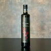 A single bottle of Melanzana Fig Balsamic Vinegar stands alone on a warmly inviting yet simple background