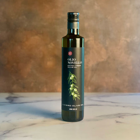 A single bottle of Olio Novello on a copper and marble counter top