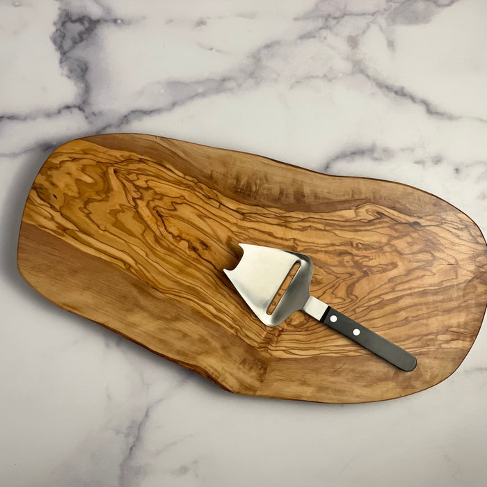 Handsome medium sized olivewood board shown with a German cheese slicer for scale. Cheese slicer is a prop and not included for sale.