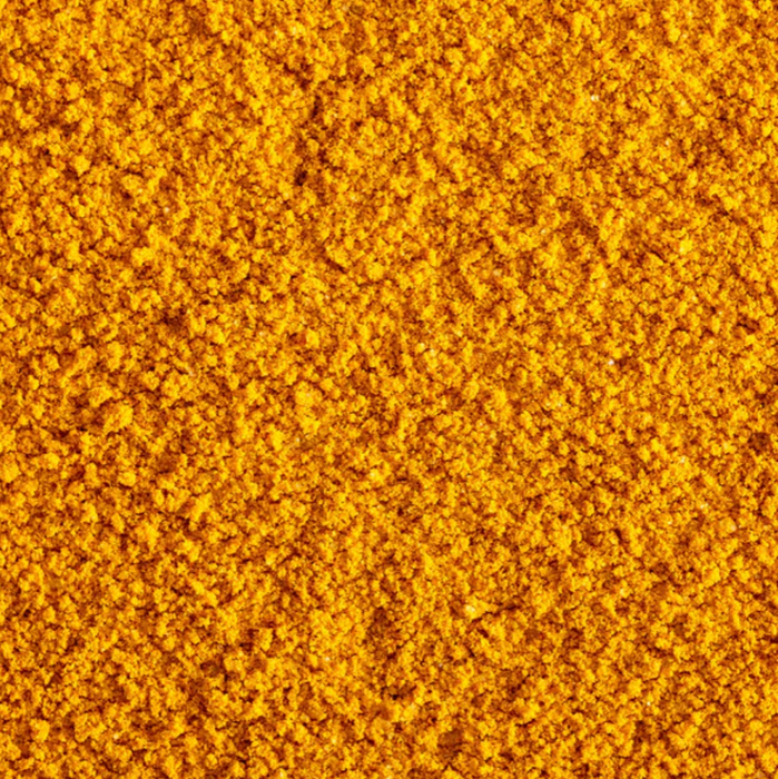 Super close image of the Turmeric Popcorn seasoning spread out so the seasoning itself can be perceived