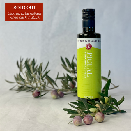A bottle of Picual is shown with fresh Picual olives around the base and a sign advising the item is sold out, but that you can click through to ask to be notified when back in stock