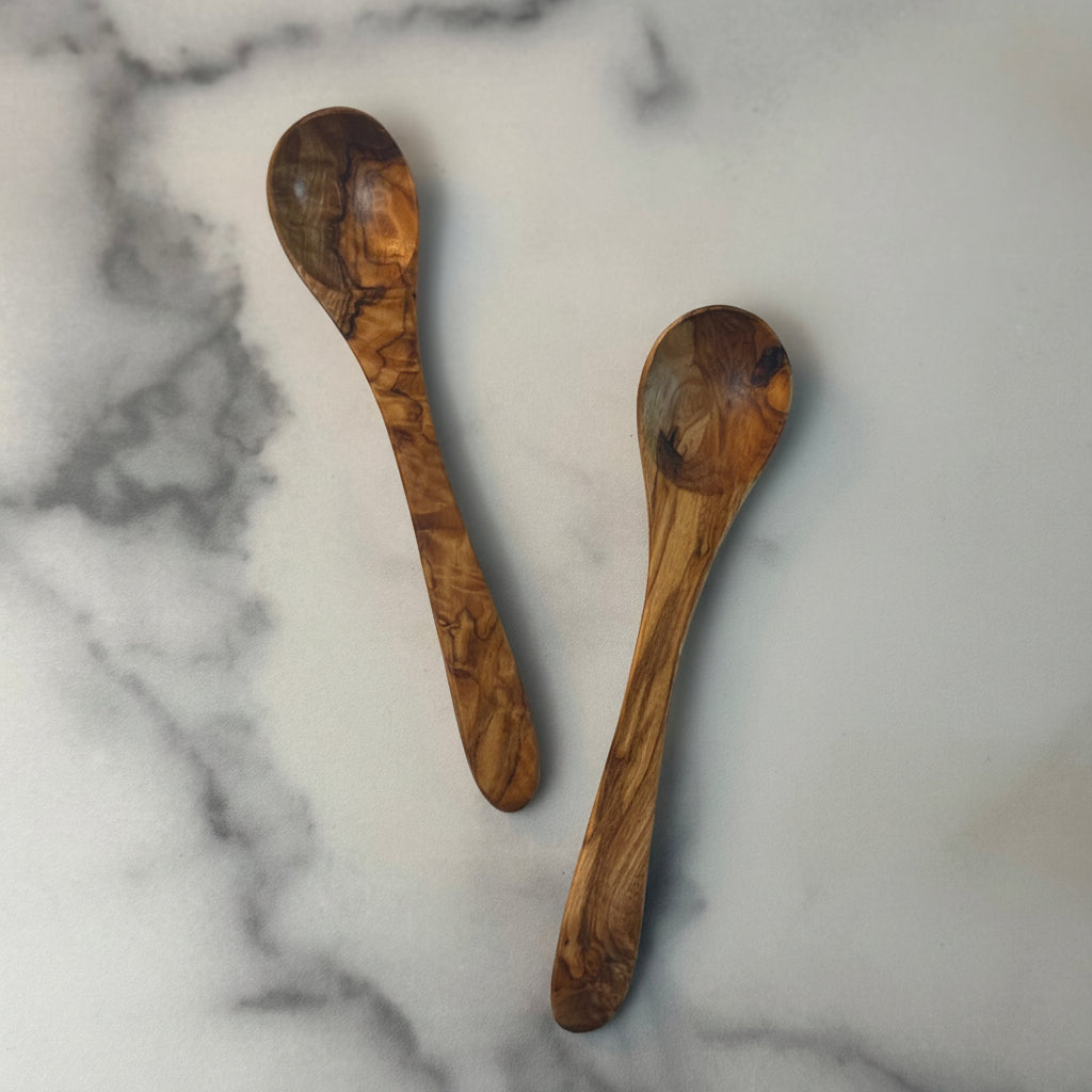 Two wooden spoons on a marble surface