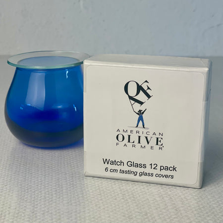 A small box showing the label American Olive Farmer Watch Glass 12 pack next to a tasting glass for scale.