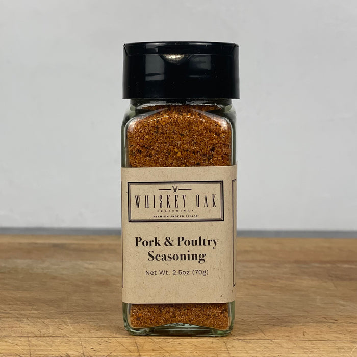 A standard glass spice jar filled with grainy spice blend sits alone on a wooden cutting board.