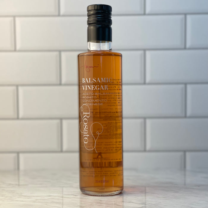 A bottle of Rosato, or Rosé, Balsamic Vinegar shown on a white marble counter top.  Edit alt text