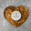 A tin of Kitchen Wood Butter sits in the middle of a heart shaped olivewood board