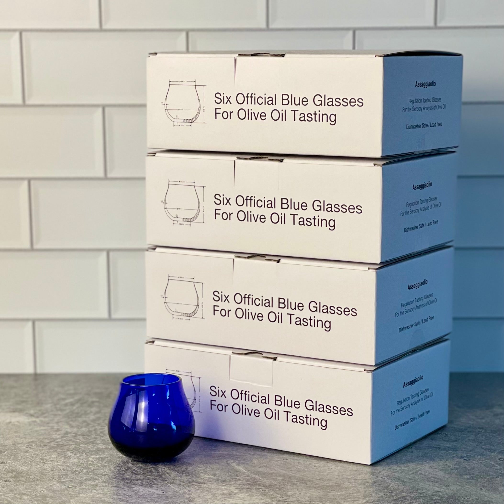 Stack of four boxes of Tasting Glasses, 6 per box or 24 total. One of the glasses is shown out of the box.