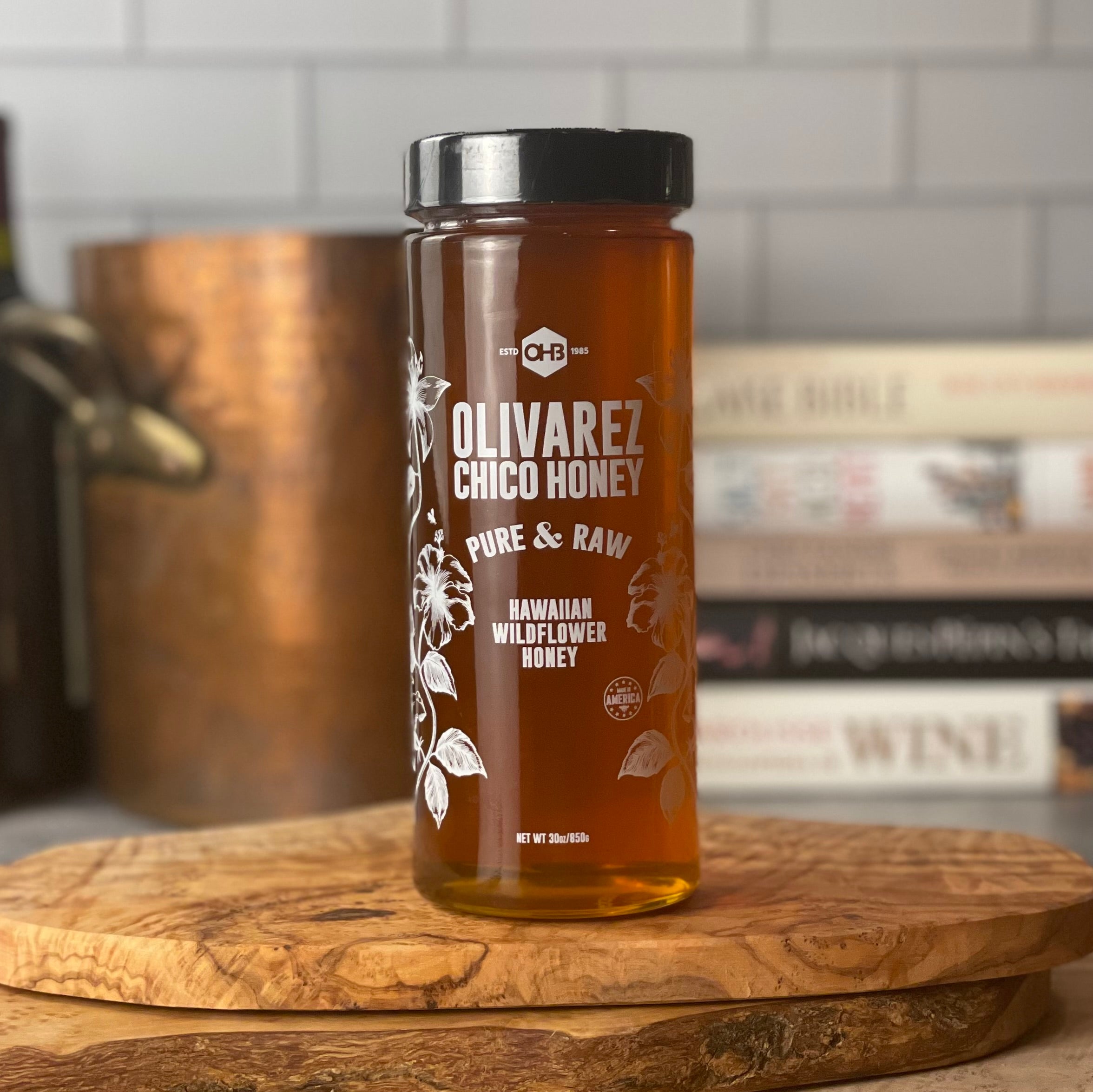 Hawaiian honey, in a large 30 oz jar, shown in kitchen near copper stock pot