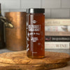 Large 30 oz jar of California honey shown in kitchen near copper stock pot