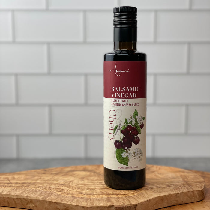 Amarena Cherry Balsamic Vinegar shown in a white tile kitchen on top of an olivewood board