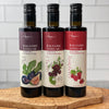 The trio three fruit balsamic vinegars, fig, cherry, and raspberry are shown together on an olivewood board.