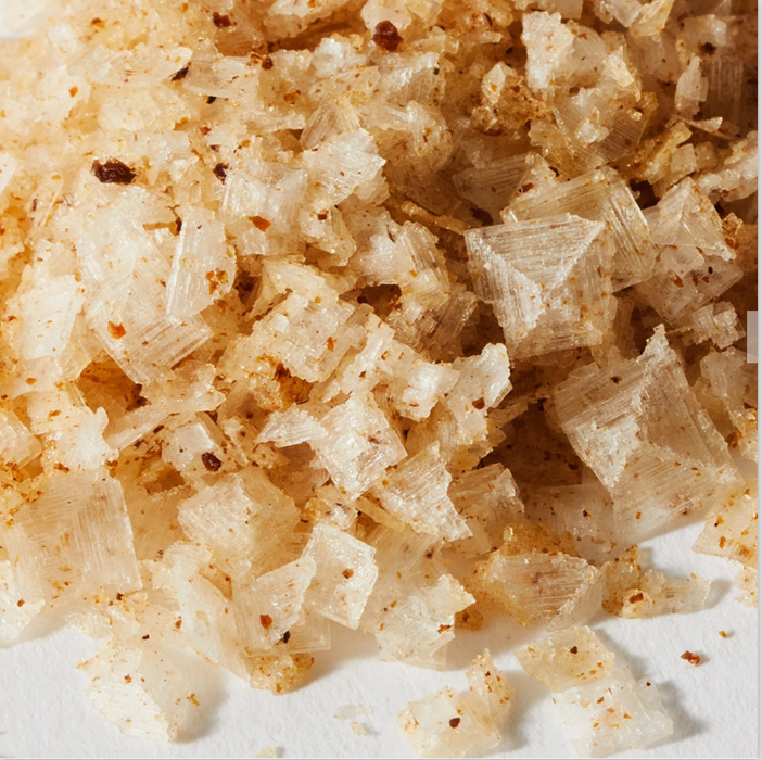 Close up image of pyramids of salt crystals; their color darkened and surface flecked with bits of truffle.