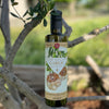 A bottle of Lucero Roasted Garlic Olive Oil placed in a young olive tree.