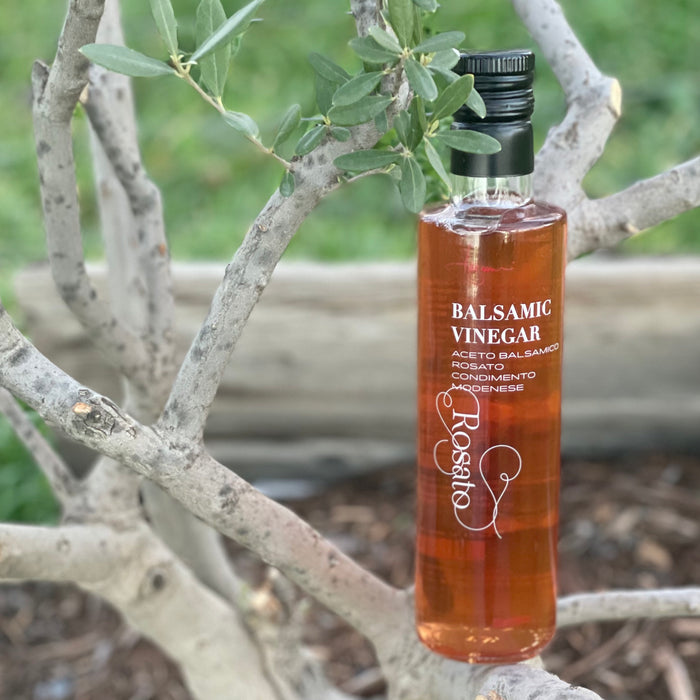 Delicate pink rosé balsamic vinegar rests in the branches of a young olive tree in Corning.