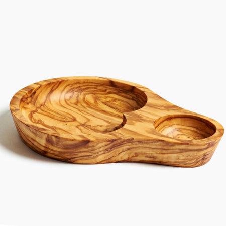 An empty olive dish, made from one piece of carved olivewood, is depicted on a plain white background