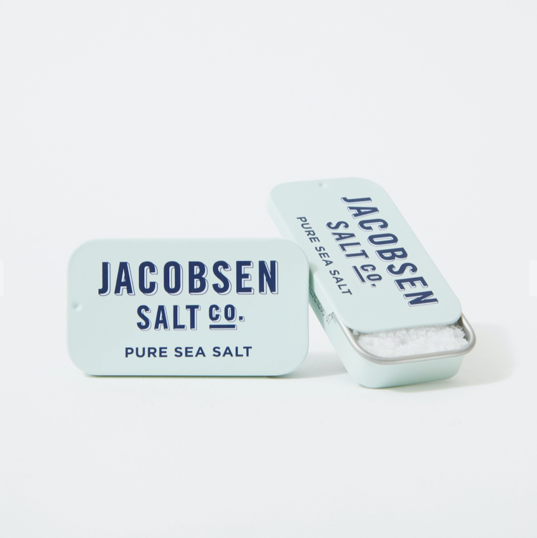 Two tiny tins of salt, (less than half the size of a tin of Altoid mints) are shown with one tin open and one closed.