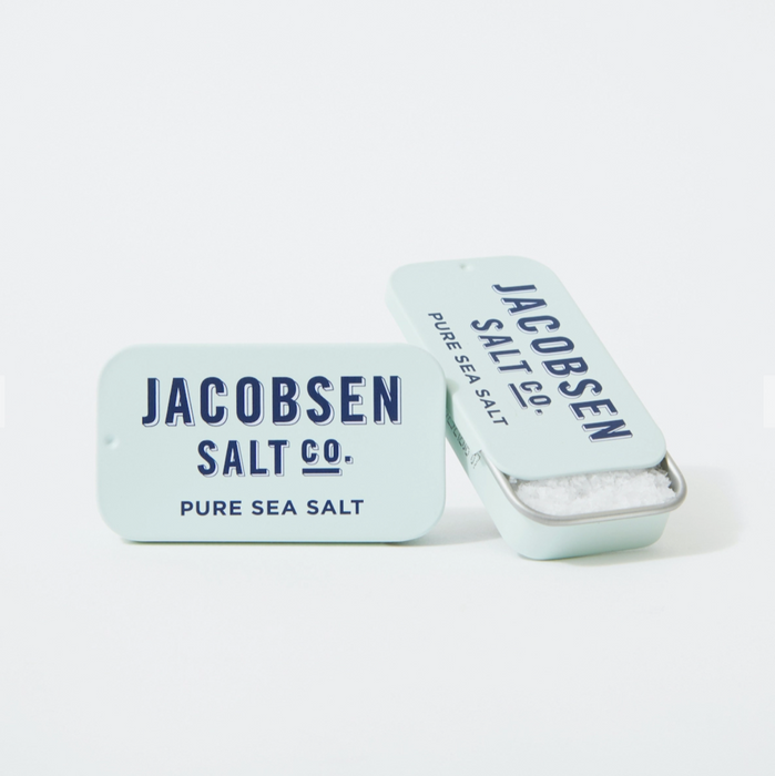 Two tiny tins of salt, (less than half the size of a tin of Altoid mints) are shown with one tin open and one closed.