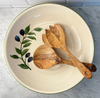 Pair of olivewood salad servers shown in a ceramic salad bowl painted with an olive branch motif