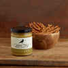 The Sweet Roasted Garlic Mustard is in the foreground, and an olivewood bowl full of thin pretzels is in the background.