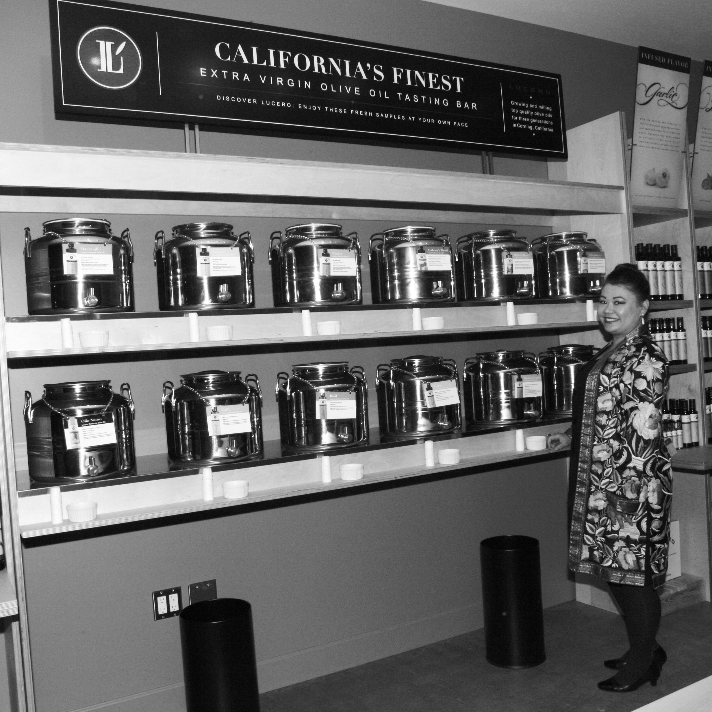 Vintage photo of Liz at the Corning Store opening October 2010 standing in front of the 12 fusti containers