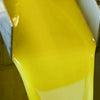 Bright opaque golden-orange olive oil, freshly milled, flows from the decanter into a holding tank.