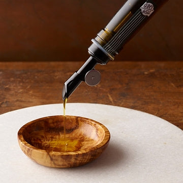 Olio Novello is poured into an individual olivewood dipping bowl.